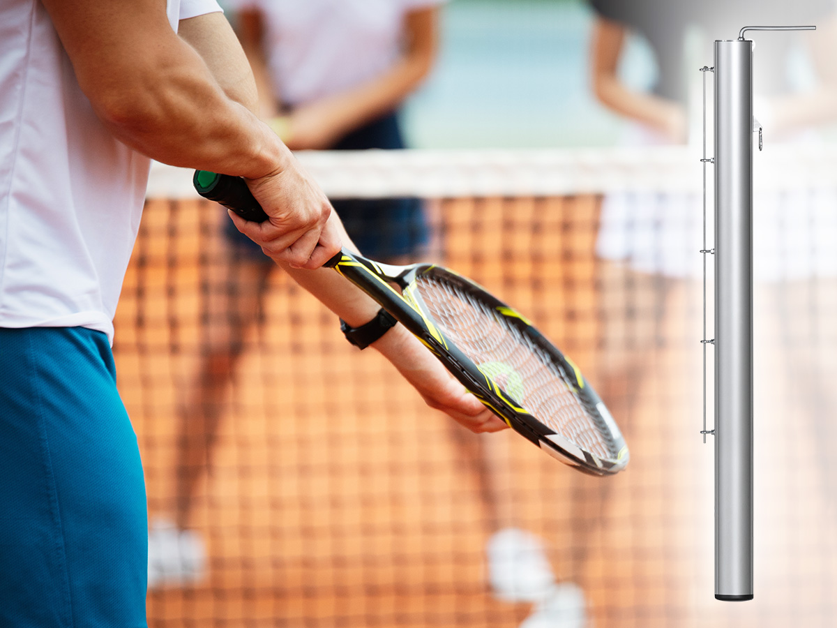 Close-up van een tennisser die opslaat, met rechts een losse tennispaal afgebeeld