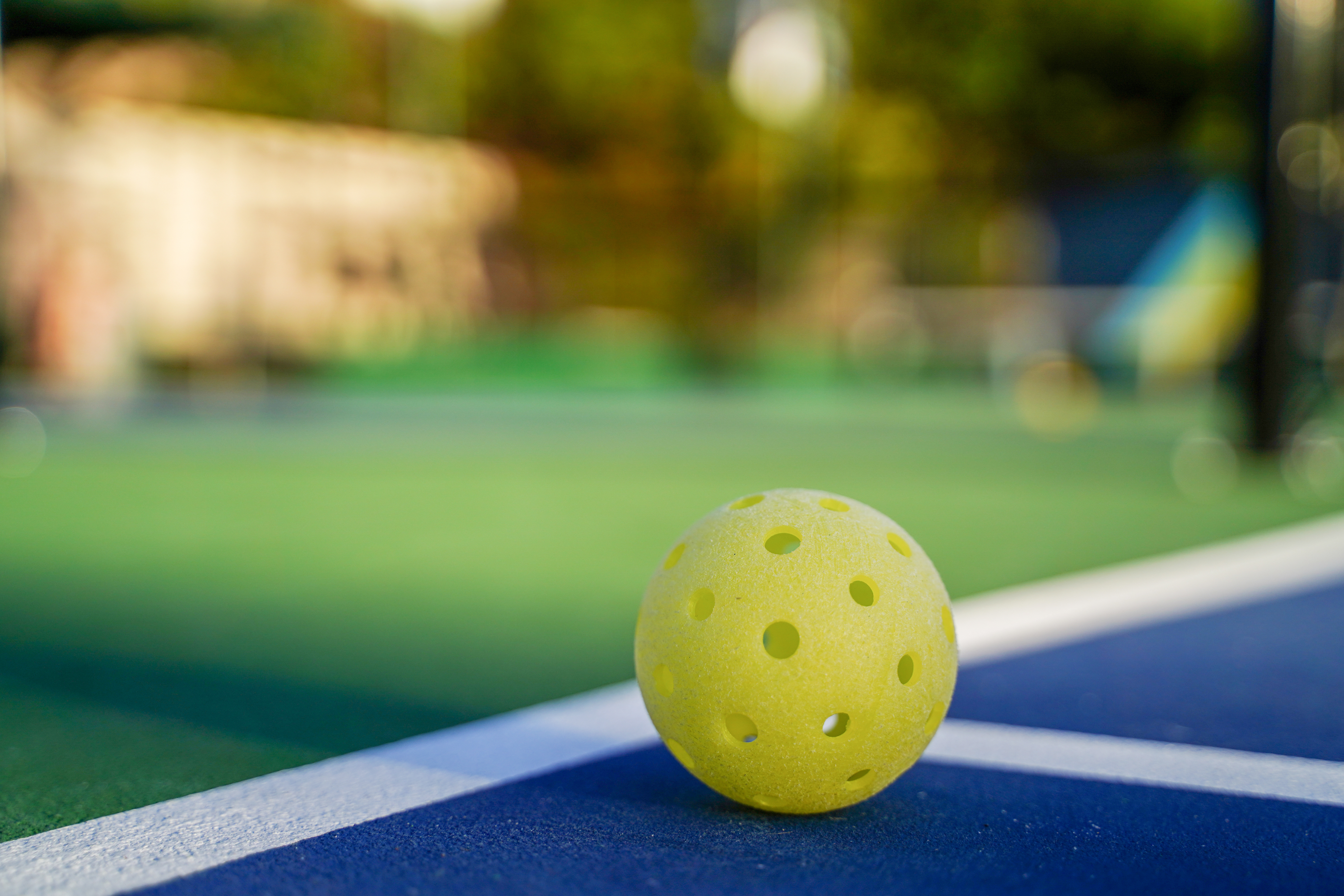 Pickleball ball ligt op een buitenvleld